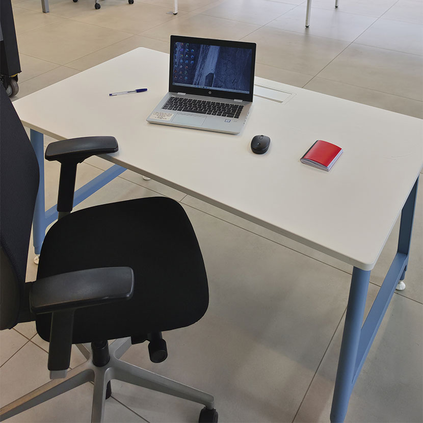 Table de bureau professionnelle CLEN Nouvelle Vague avec plateau blanc, piètement métallique bleu et Top Access central pour la gestion des câbles.