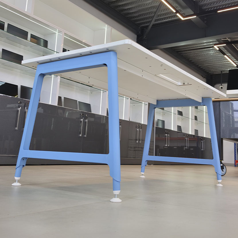 Table de bureau professionnelle CLEN Nouvelle Vague avec plateau blanc, piètement métallique bleu et Top Access central pour la gestion des câbles.